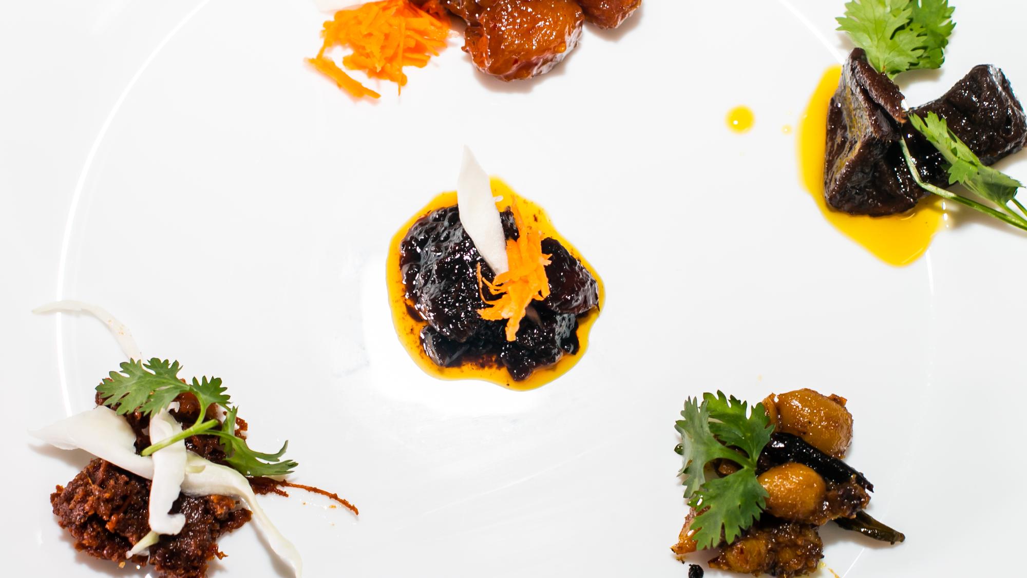 Styled plated appetizer with vibrant sauces