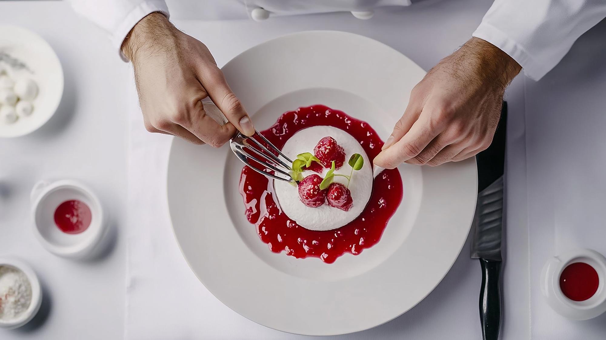 Chef plating a dessert with delicate garnishes